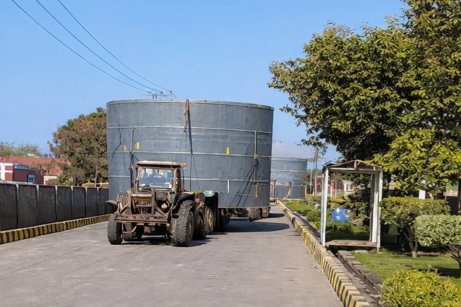 Large-scale industrial FRP storage tank being transported on a heavy-duty trailer for delivery by Global Fiberglass Company.