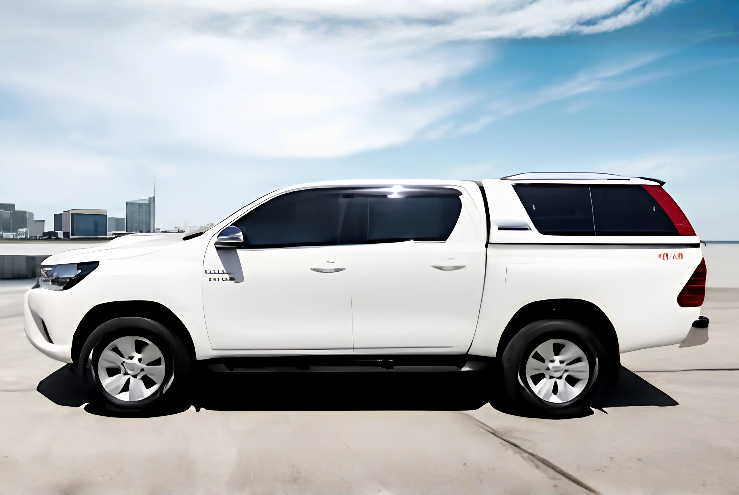 A white Toyota Hilux double cabin pickup truck equipped with a premium GRP/FRP truck canopy and hardtop body from Global Fiberglass Company.