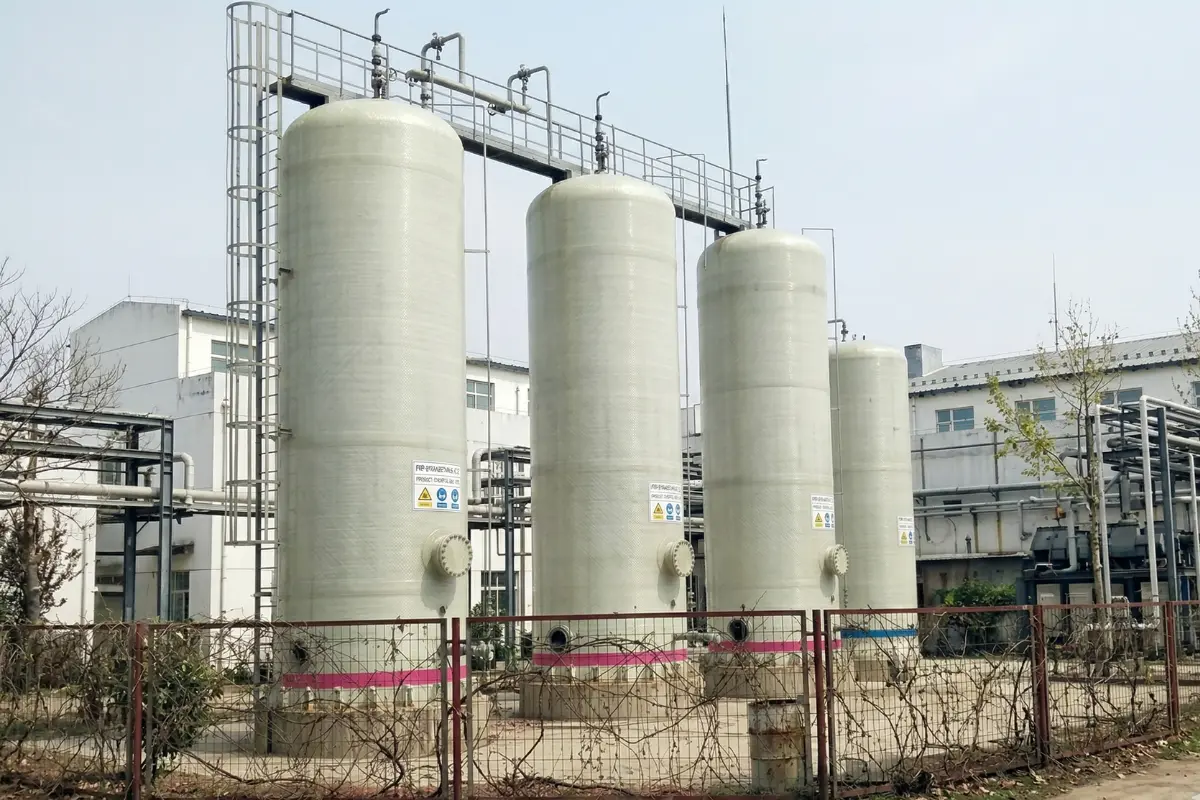 Row of industrial Vertical Cylindrical FRP storage tanks installed at a chemical manufacturing facility by Global Fiberglass Company.