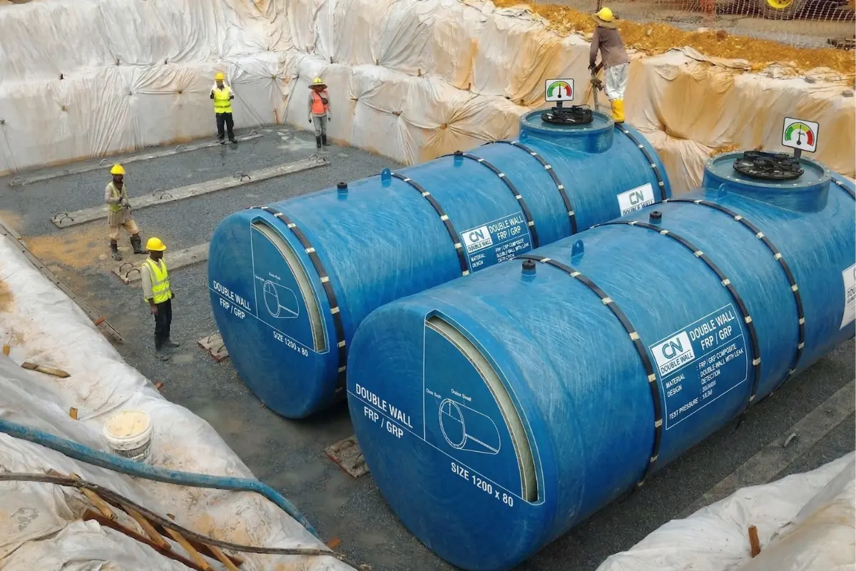 Installation of blue industrial Double Wall FRP/GRP underground storage tanks at a construction site by Global Fiberglass Company.
